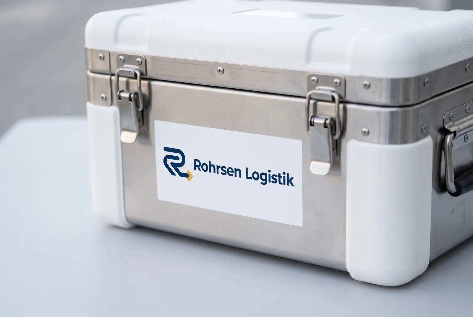 Weiße Transportbox mit UN-3373-Kennzeichnung auf einer Edelstahlfläche